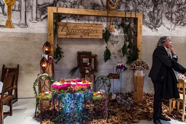 Florale Hochzeitsdekoration vor freskierten Wänden im Schloss