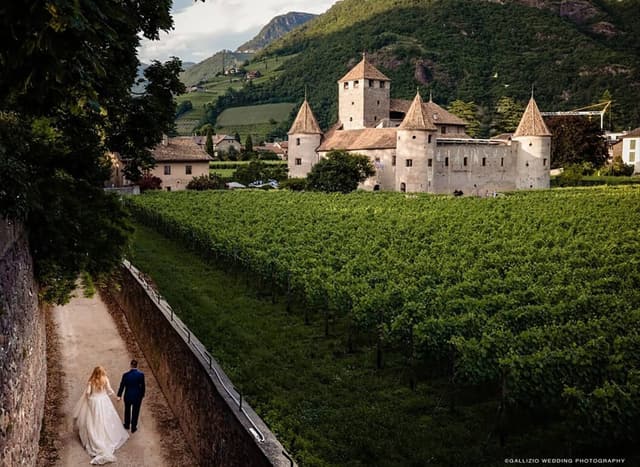 Brautpaar spaziert an den Weinbergen entlang auf Schloss Maretsch in Bozen zu